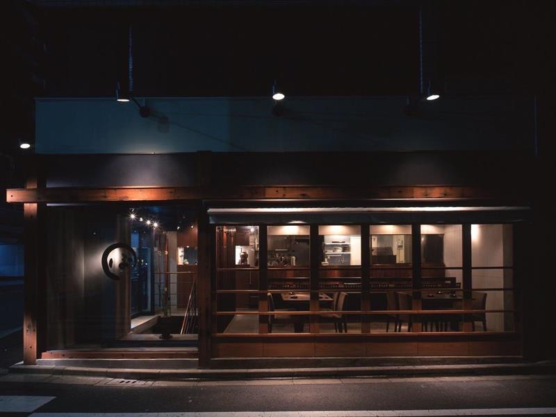 夜の街路に面した木質の店舗外観